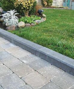 Grey concrete curbs separating grass and concrete paving stones