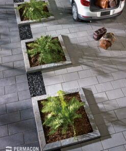 three garden beds made out of grey concrete curbs on top of a paving stone driveway